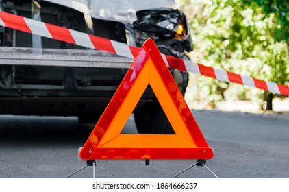 Red Emergency Stop Triangle Sign And Red White Police Tape On Road In Front Of Car Accident. Broken Suv Car In Road Traffic Accident. Car Crash Traffic Accident On City Road After Collision