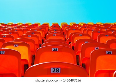 red empty plastic seats in the stands of fans at the sports stadium