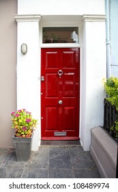 Red Entrance Door In Front Of Residential House