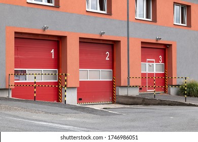 Red entrance gates to a Czech fire station where the fire trucks are parked and ready for emergency situation