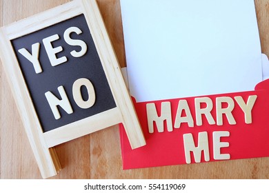 Red envelope with empty paper over wooden background