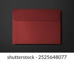 Red envelope on a dark background. The envelope is closed, with a flap. Red envelope, dark background, closed flap, red envelope.