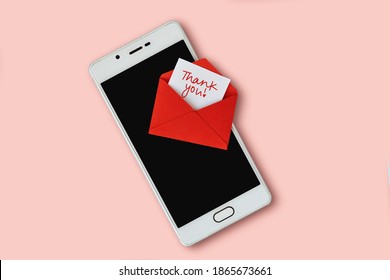 Red envelope and thank you letter with mobile phone on pink background
