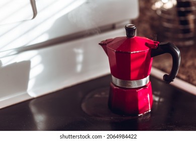 Red Espresso Pot Brewing Coffee On Glass Stovetop In The Morning