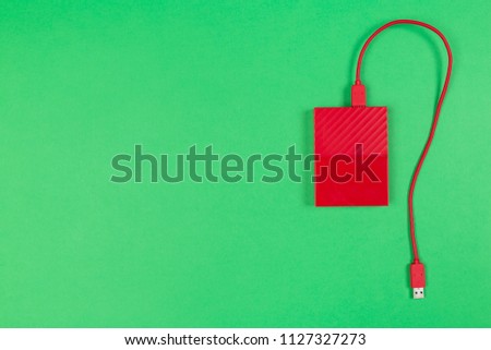 Red external harddrive disk on colored background