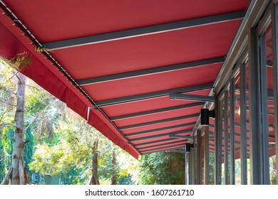 Red Fabric Awning With Steel Structure Roof Of Coffee Shop In Garden.