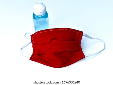 A Red Fabric Or Face Masks And Alcohol Gel Isolated On White Background, It’s For Prevention From Some Dirt And Bacteria. Cloth Mask Can Be Used As Surgical Masks But Can Not Protect Virus Covid-19.