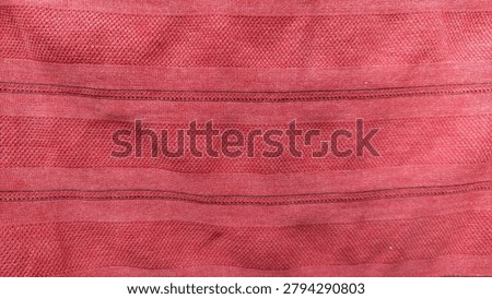 red fabric texture, Close up of red fabric texture with stitching pattern showing neat textile fiber details.