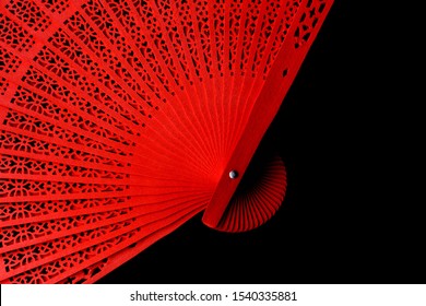 Red fan with a pattern closeup. Isolate on black background