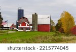 A red farm with silo and the background of fall foliage near Upstate New York, U.S.A