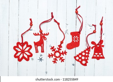 Red Felt Christmas Ornaments On White Wooden Table Background