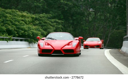 Red Ferrari Enzo and F430 on the road in Singapore
