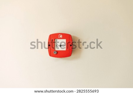 Red fire alarm button on wall