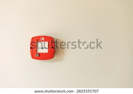 Red fire alarm button on wall