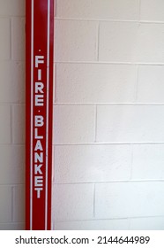 Red Fire Blanket Box Mounted On A White Cinder Block Wall. Fire Safety And Protection