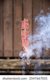 Red fire crackers string exploding with smokes background. Festival or celebration decoration equipment