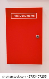 Red fire document box mounted on white wall, emergency fire safety equipment in building