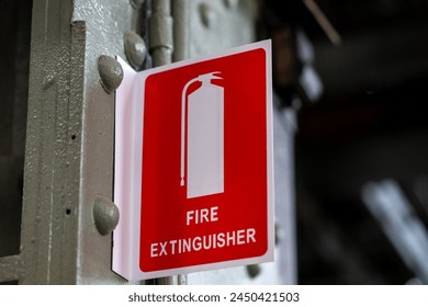 Red fire extinguisher sign on wall of old power station