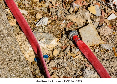 Red Fire Hose With Fitting On A Ground