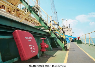 Red Fire Hose Reel, Mounted On Deck Cargo Ship Under Repair In Shipyard