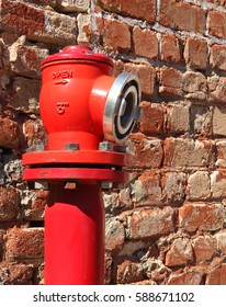 Red Fire Hydrant against Old Red Brick Wall on the Street
