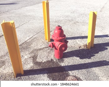 red fire hydrant between 3 yellow poles