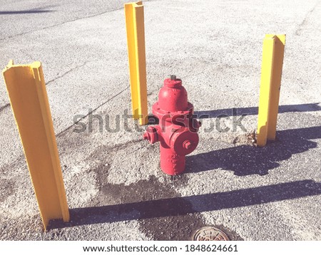 red fire hydrant between 3 yellow poles
