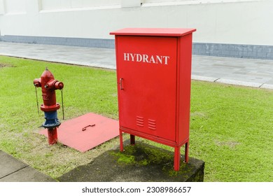 Red fire hydrant box and firefighting equipment.