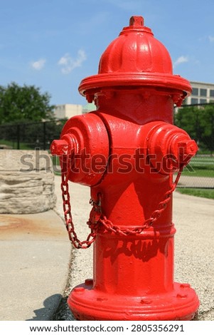 Red fire hydrant with red chain with blue sky background