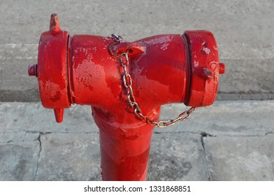  Red Fire Hydrant  Or Red Fire Department Connection, Installed On The Side Of The Road In The Community As A Water Supply Point For Outdoor Fire Extinguishers On Cement Floor Background.