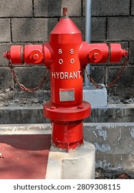 Red Fire Hydrant for Emergency Use

A bright red outdoor fire hydrant pillar with two outlets, mounted on a concrete base against a gray brick wall. This essential firefighting equipment provides firefighters with immediate access to a high-pressure water supply during emergencies.

