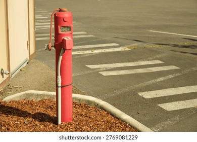 A red fire hydrant is in the frame. A bright red fire hydrant standing outdoors as part of urban infrastructure, symbolizing emergency preparedness, public safety, and firefighting access in a city street environment.