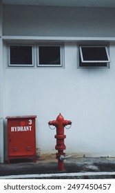 Red Fire Hydrant in Front of White Building Wall with Three Windows