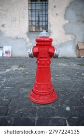 red fire hydrant installed next to a wall
