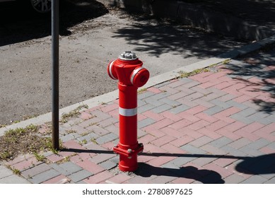 Red fire hydrant on paved footway in Bucharest, Romania