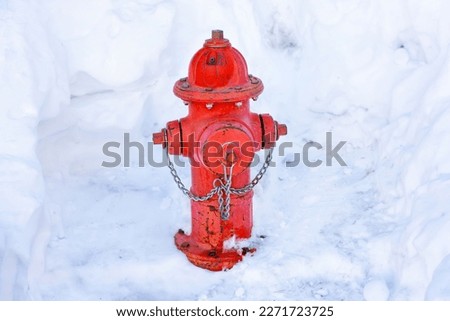Red fire hydrant in a snowdrift. Winter safety concept.
