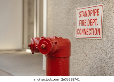 A red fire hydrant stands next to a wall-mounted emergency sign. The image emphasizes urban safety infrastructure in New York City.