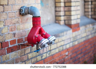 Red fire hydrant in the wall of a brick house in the city streets