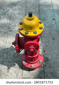 Red Fire Hydrant with Yellow Cap on Urban Sidewalk