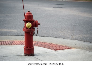 Red fire hydrant with yellow cap on sidewalk. Infrastructure and safety design element with copy space.