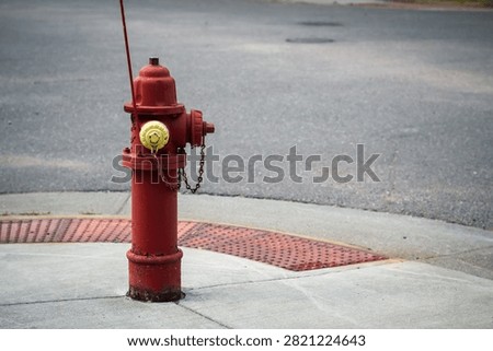 Red fire hydrant with yellow cap on sidewalk. Infrastructure and safety design element with copy space.