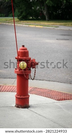 Red fire hydrant with yellow cap on sidewalk. Infrastructure and safety design element with banner or background.