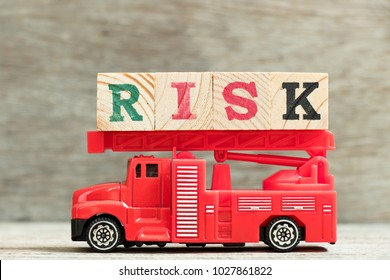 Red Fire Truck With Ladder Hold Block Word Risk On Wood Background