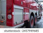 A red fire truck with a retractable ladder. Equipment for rescuing people in case of fire. The rescue service. The fire extinguishing equipment is located in the compartments of the fire truck.