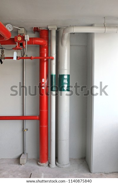 Red fire water pipeline system and sewer pipe\
in car park building.