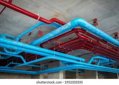 Red Fire Water Pipes On The Concrete Wall In The Condo Building.Installation Of Drainage Pipes In The Building.Sanitary System Of A Condominium.water Piping System Install With The Concrete Ceiling.