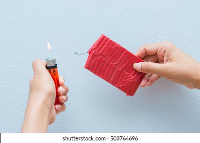Red firecrackers and a lighter in hand, dangerous
