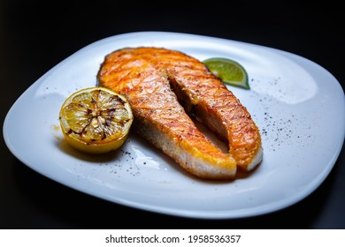 Red Fish Fillet Cooked On Grill.Salmon Steak Grilled For Dinner In Sea Food Restaurant,served On White Plate With Lemons.Download Royalty Free Curated Images Collection With Foods For Design Template