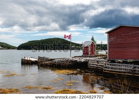 Red fishing sheds in rural Newfoundland community on the ocean.
