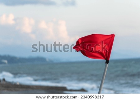 Red flag by the sea in the evening